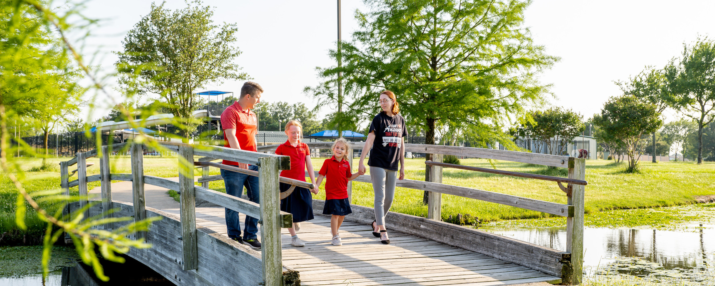 Family walking over a bridge in a local park