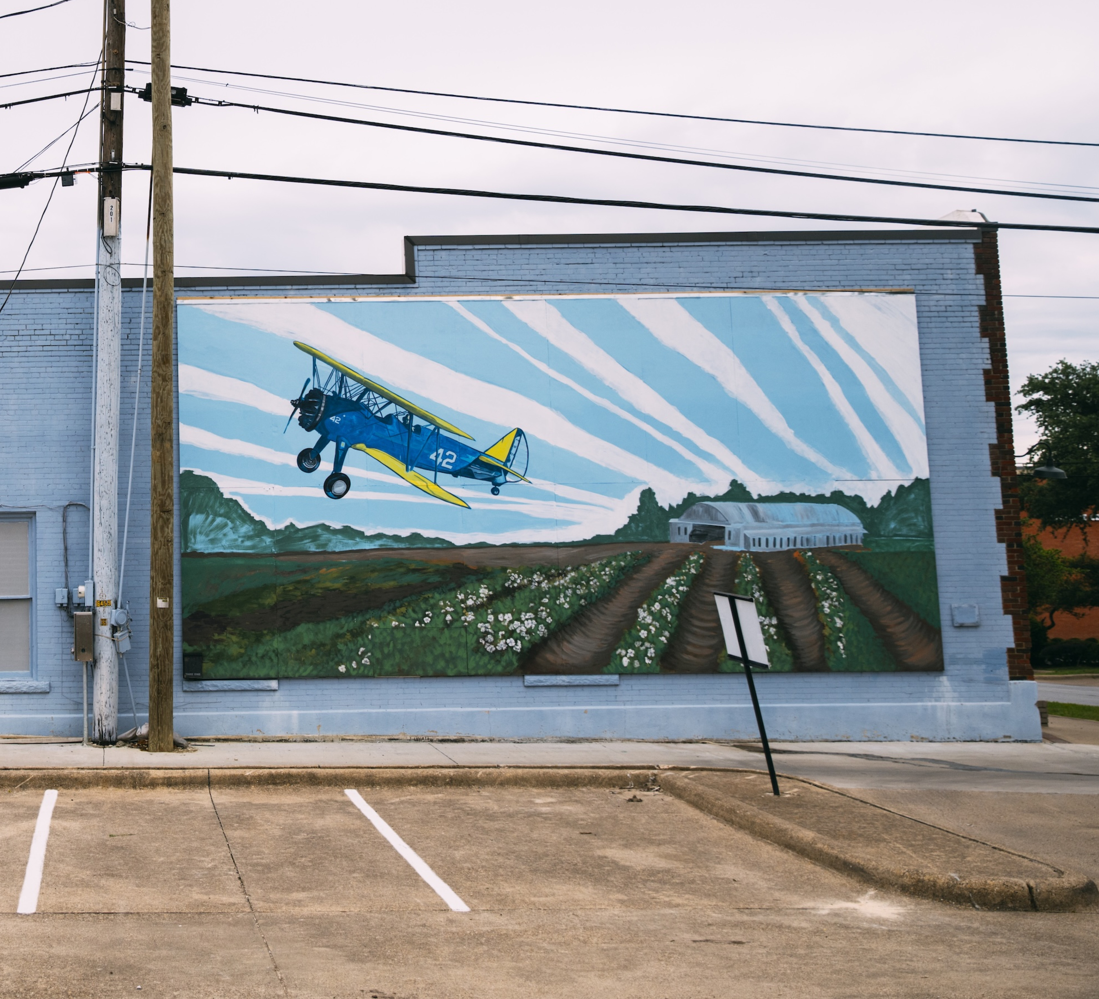 downtown mural of an old airplain flying over a field